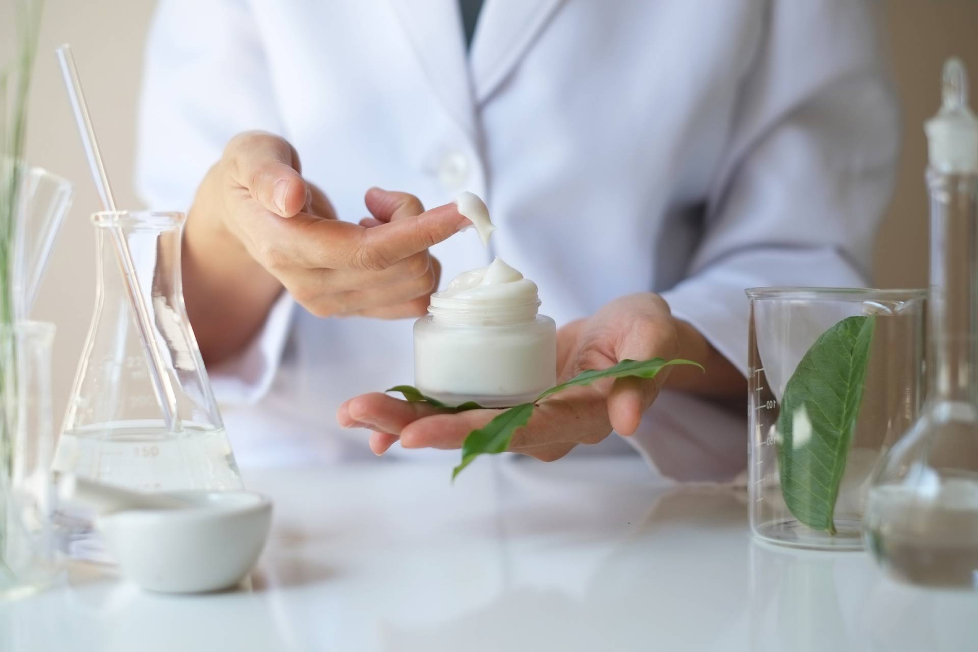 Scientist handling cream with natural ingredients.