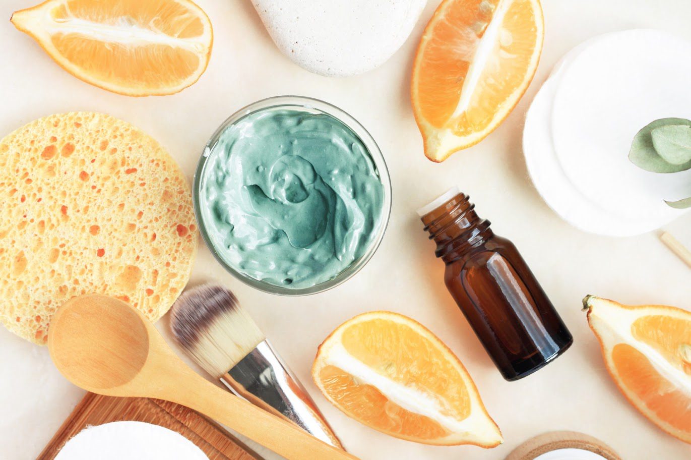 Skincare items with citrus slices and brush.